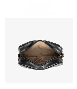 Top view of black leather wave pattern crossbody bag with gold zipper and brown lining