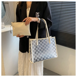Detail of trendy PU tote set with monogram PVC exterior and matching inner pouch