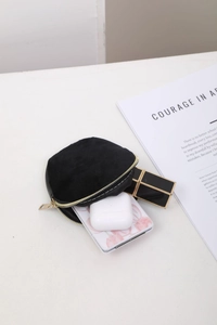 Detail of black velvet drawstring bag showing compact interior for lipstick and earbuds