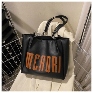 Détail du sac cabas noir avec broderie MCAORI et anneaux métalliques argentés élégants