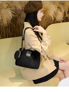 Black velvet tote bag with gold chain strap and mini coin purse worn with a beige trench coat