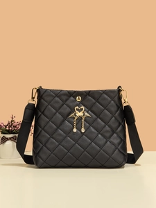 Détail du sac seau matelassé noir avec pendentifs cygnes dorés et bandoulière