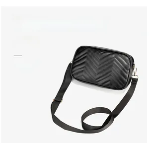 Detail of black wave quilted crossbody bag showing dual interchangeable shoulder straps