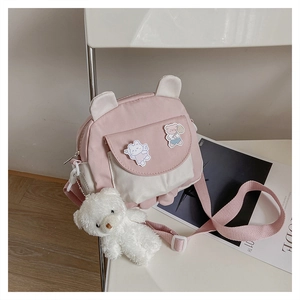 Close-up of pink and white crossbody bag with cute animal ears and plush bear charm