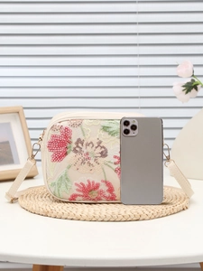 Dettaglio del ricamo floreale con paillettes su borsa crema con telefono per scala taglie