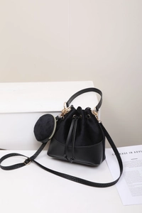 Detail view of black drawstring bucket bag with velvet texture and detachable round coin purse