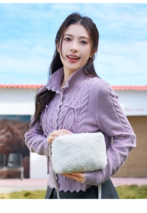 Détail d'un sac à main blanc en fausse fourrure avec un cardigan en maille lilas