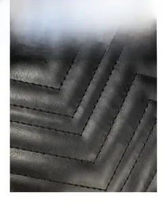 Close-up of black quilted leather with chevron stitching and premium texture detail