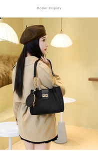 Detail of black suede tote with gold chain accent and round coin purse accessory