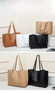 Detail of multi-color large tote bags with smooth faux leather texture and side charms