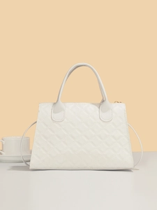 Close-up of white quilted leather bag with elegant stitching and gold zipper details
