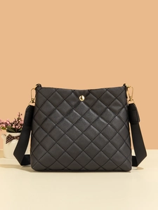 Détail d'un sac seau matelassé noir avec finitions dorées et bandoulière tissée