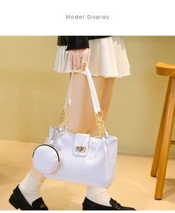 White canvas bucket tote with golden chain strap and round coin purse shown on model