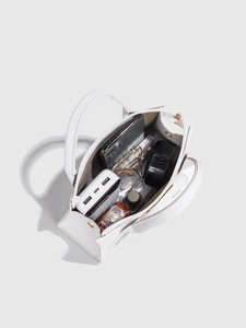 Top view of white pebbled leather bag interior showing spacious capacity and daily items