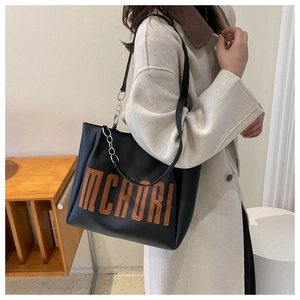 Détail du grand sac cabas noir avec chaîne argentée et motif de lettres marron