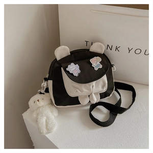 Detail of cute rabbit ear crossbody bag with bear patches and plush bear charm