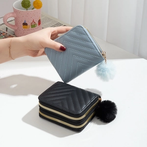 Portefeuille matelassé chevron avec pompon en fourrure et double zip en bleu et noir