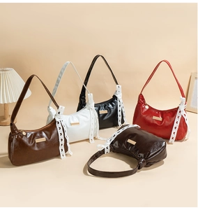 Detail of hobo shoulder bag with a large lace bow and elegant gold metal buckle