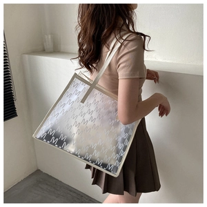 Close-up of frosted semi-transparent tote bag with repeating M-letter print and white trim