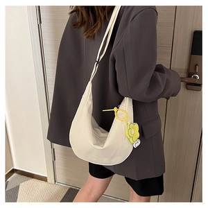 Vue détaillée du sac à bandoulière blanc en croissant avec breloque fleur jaune