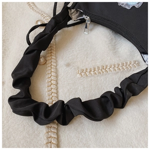 Detail der schwarzen Stoffhandtasche mit gerafftem Schultergurt und silbernem Reißverschluss