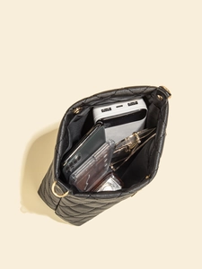 Vue du dessus de l'intérieur spacieux d'un sac seau noir matelassé avec accessoires