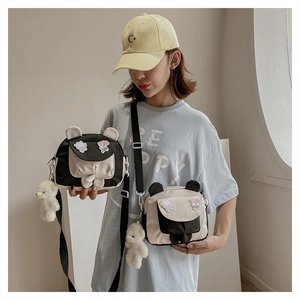 Detail of cute panda-ear crossbody bag featuring cartoon patch and plush bear charm