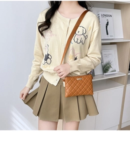 Brown quilted crossbody bag styled with a beige cardigan and pleated skirt outfit
