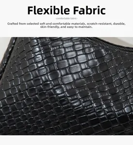 Détail macro de la texture croco tissée brillante sur le sac bandoulière noir robuste