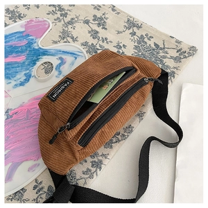 Close-up of brown corduroy chest bag with adjustable strap and double zipper pockets