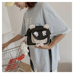 Detail of cute rabbit ear crossbody bag featuring bear pendant and cartoon patches
