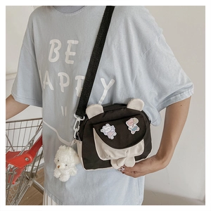 Detail of cartoon bunny ear crossbody bag with teddy bear pendant and adjustable strap