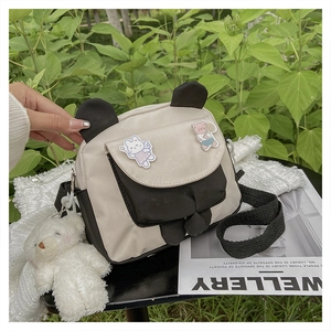 Detail of panda crossbody bag featuring cute bear embroidery and plush charm pendant