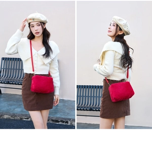 Détail du sac bandoulière en fausse fourrure rouge avec texture douce et lanière
