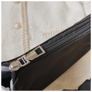 Detailansicht der schwarzen Stofftasche mit silbernem Reißverschluss und Webstruktur