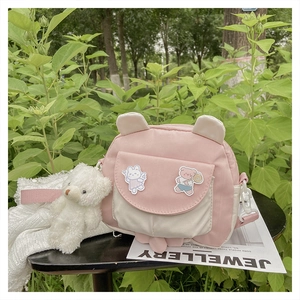 Detail of pink and white crossbody bag with cute rabbit ears and plush bear charm