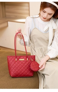 Dettaglio borsa trapuntata rossa con targhetta in metallo dorato e mini pochette tonda