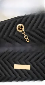 Detail of V-quilted black leather surface with premium gold hardware and grommets