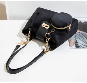 Close-up of black velvet bucket bag with gold chain strap and mini round coin purse