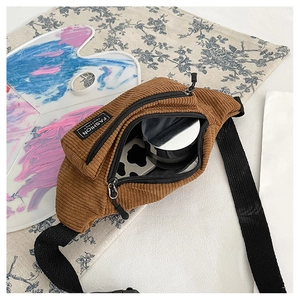 Detail view of corduroy fanny pack showing dual zippers and interior storage capacity