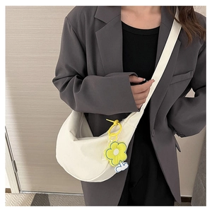 Sac bandoulière blanc en croissant avec pendentif fleur sur mannequin en blazer gris