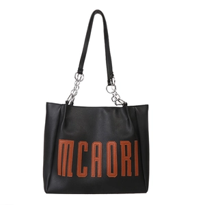 Grand sac cabas en similicuir noir avec lettrage MCAORI marron et chaînes métalliques