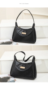 Détail du sac à bandoulière noir tissé avec motif à carreaux et garniture métallique dorée