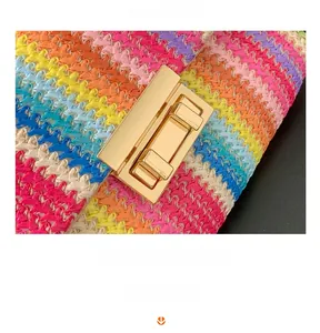 Detail of colorful woven crossbody bag with gold metallic buckle and vibrant stripes