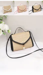Close-up of handmade straw woven bag with leather trim and elegant pearl pendant detail
