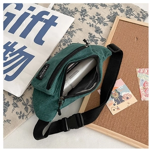Detail of green corduroy waist bag showing adjustable strap and fashion label