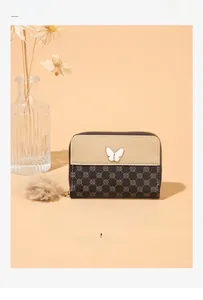 Detail of short wallet with clover pattern, metal butterfly and faux fur pompom charm