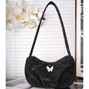 Elegant black crescent shoulder bag with white butterfly metal clasp and minimalist strap