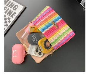 Internal view of rainbow woven straw bag showing capacity for phone and cosmetics