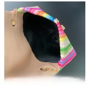 Detail of colorful woven crossbody bag showing inner lining and golden chain strap